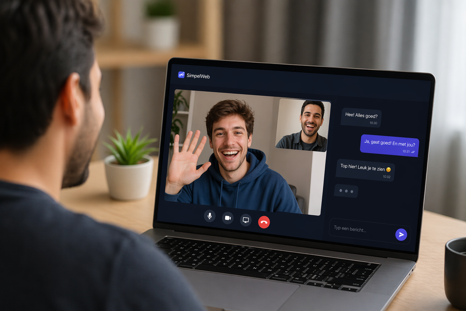 A man laughing during a video chat on his laptop